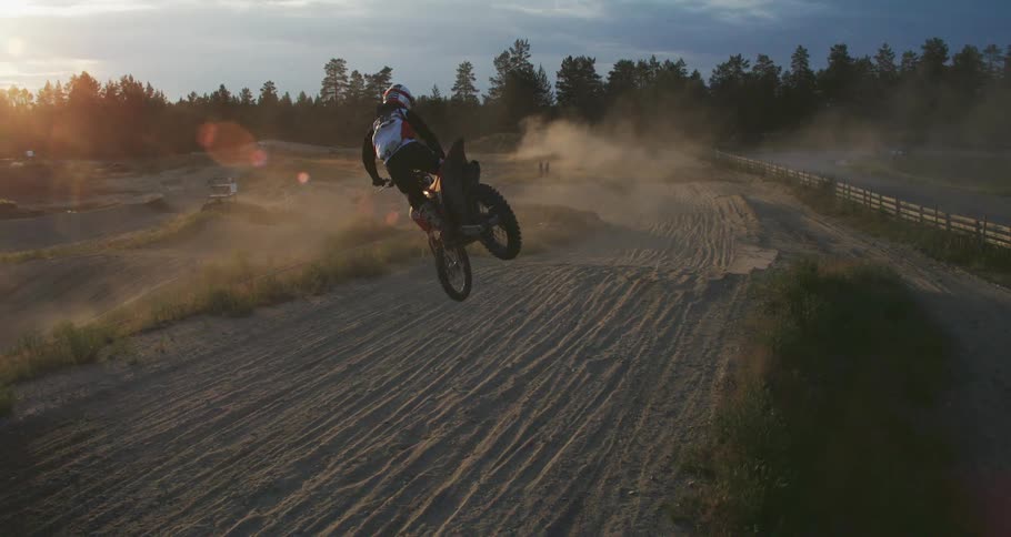 Man jumping a small hill on a motocross track