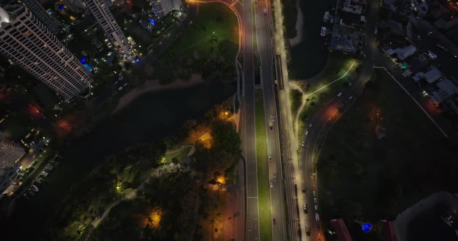 Aerial view of a highway crossing a citys tower block at night