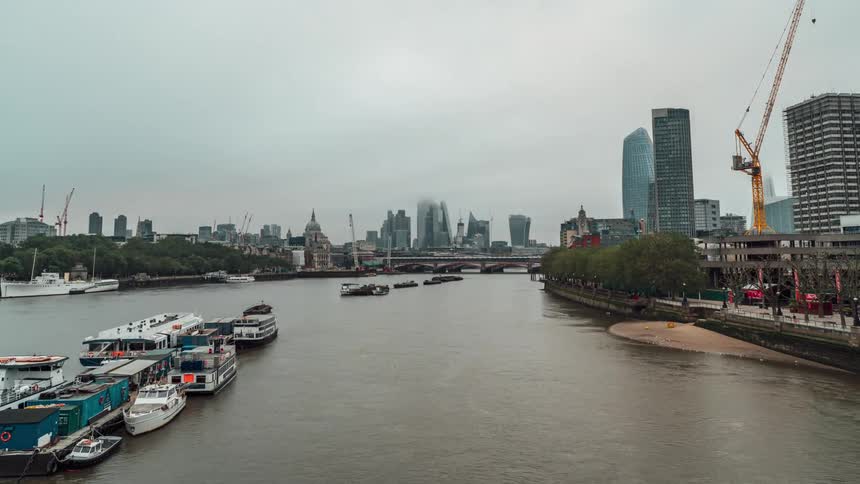 A huge river in a city with several boats stopped on the surface of the water
