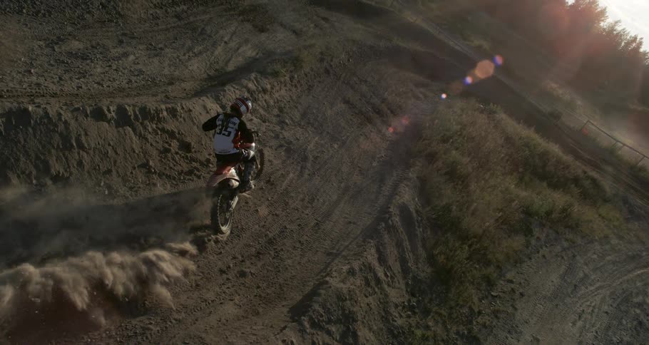 A motocross racer speeding on a dirt track