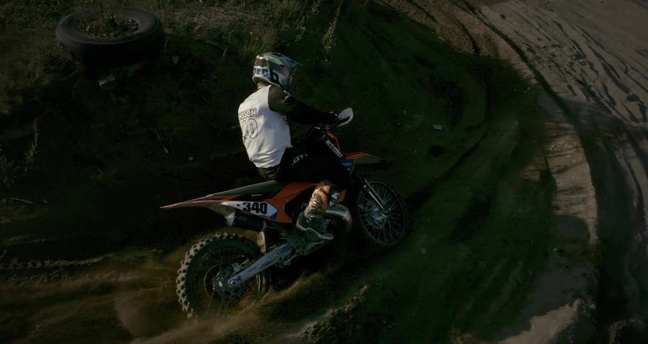 A person is skidding on the ground with a motocross bike