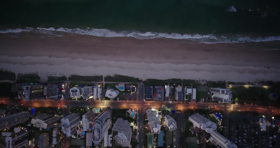 An aerial view of a beach and a city with its buildings facing the sea