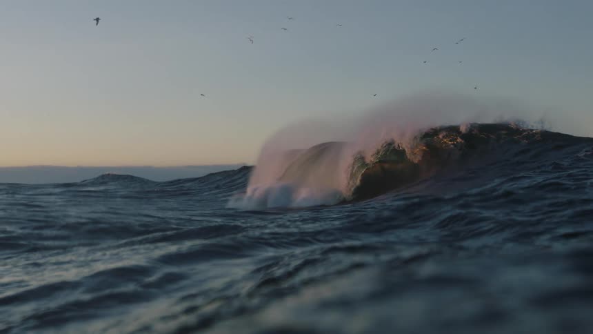 View from inside the sea with a wave breaking in slow motion