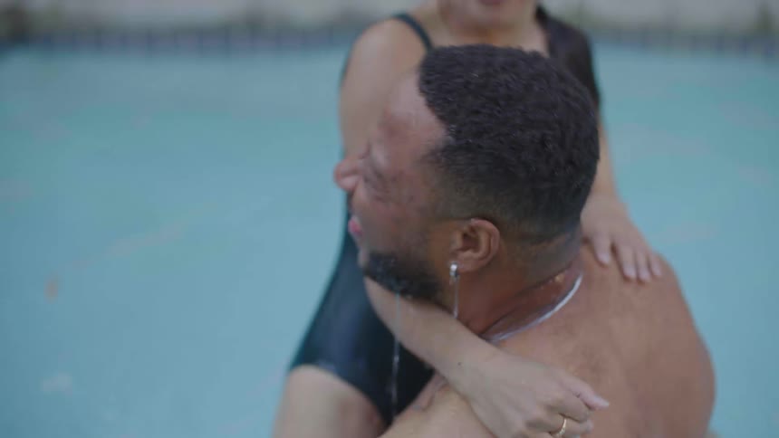 Man and woman play with one another in the swimming pool