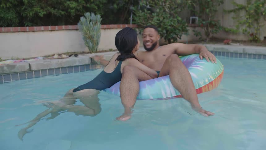 Couple conversing and swimming happily in the pool