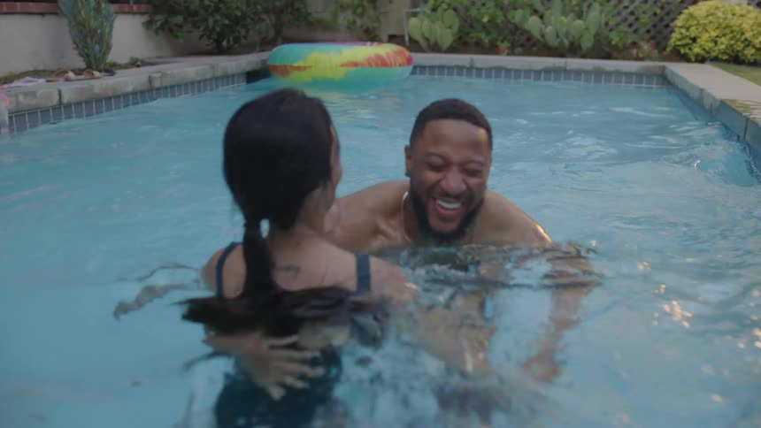 Young couple enjoy swimming in the backyard pool