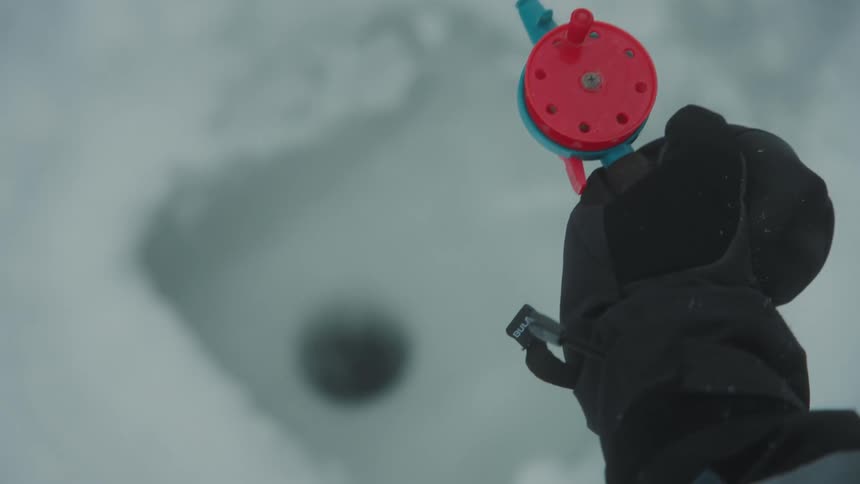 A person ice fishing on a lake