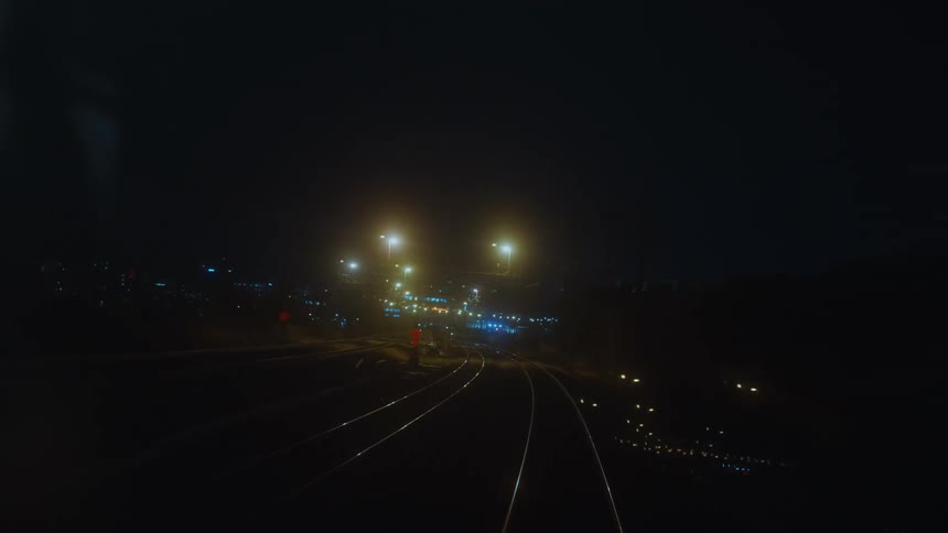View from inside the train at night of the railway track