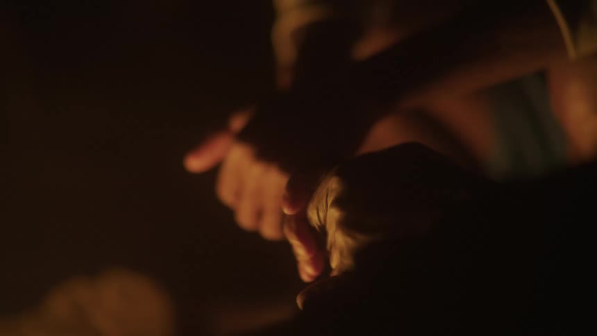 A clip of two hands heating up beside a fire