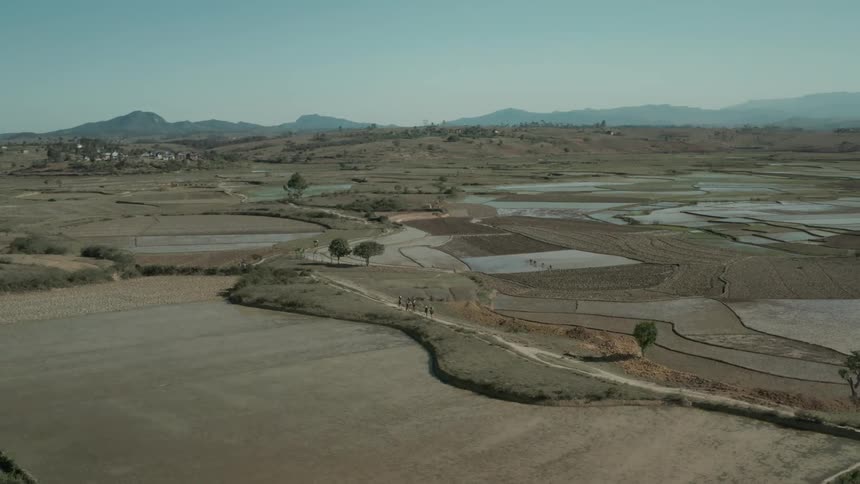 Some people walking on a path in a rural region