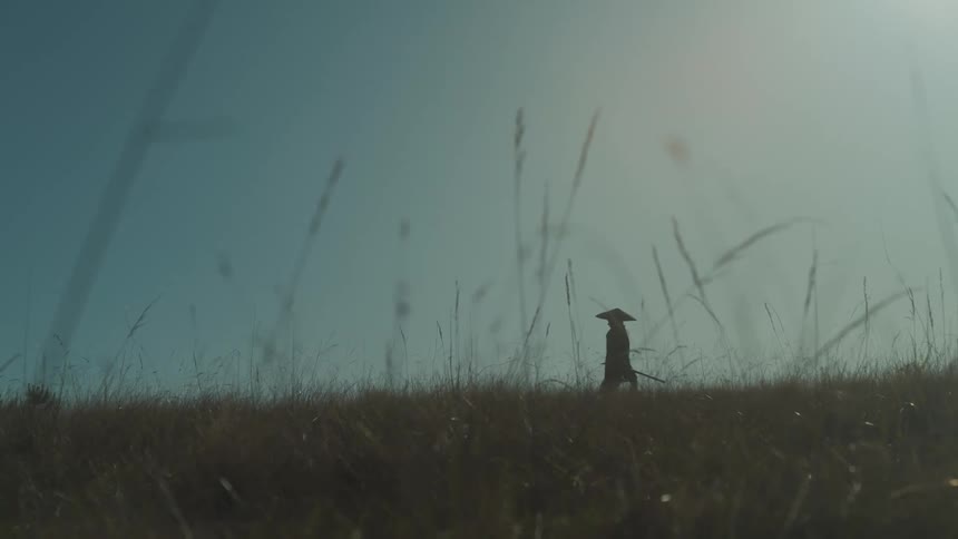 A man is hiking in the grass