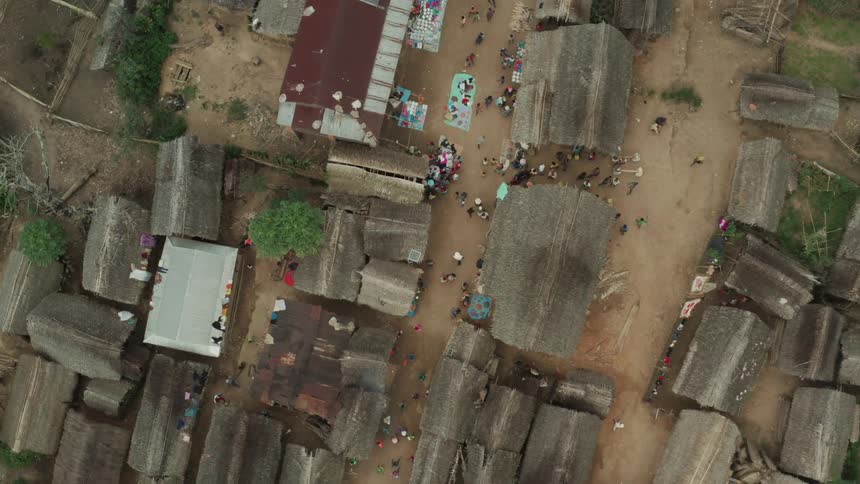 Aerial view of a rural area with small buildings with people walking on the streets