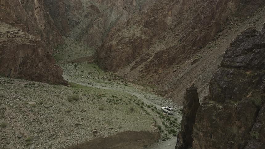 White jeep climbing a steep road through the mountains