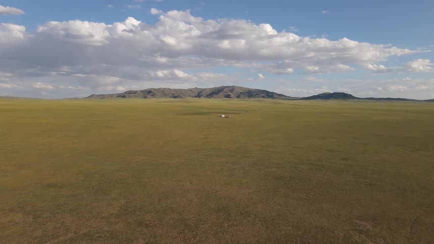 The long field leads to the mountain