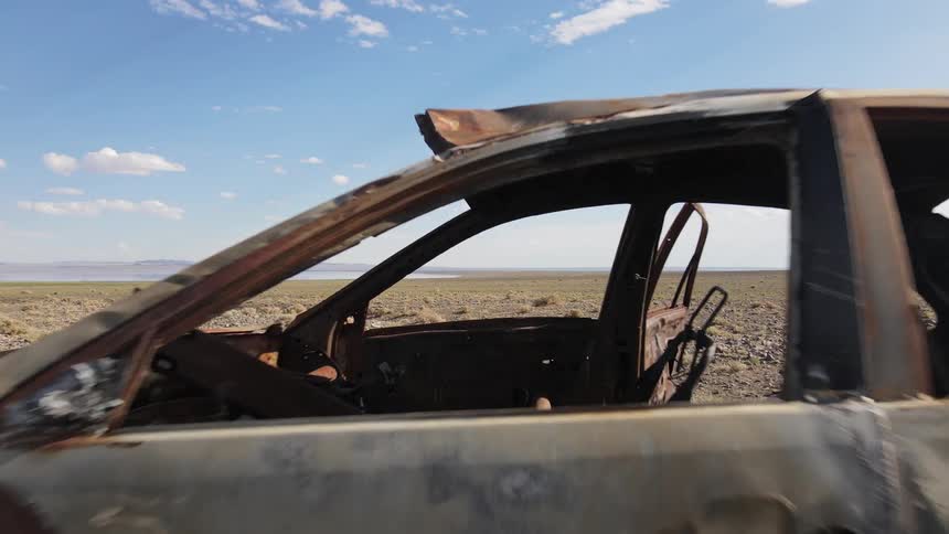 Remains of a burned car in the desert during the day