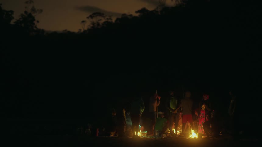 A group of people standing beside the camp fire