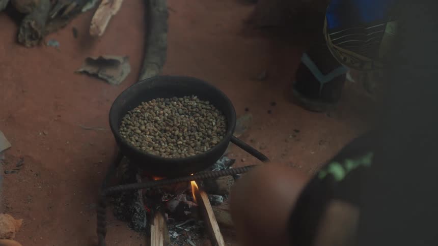 A person preparing a meal on the outdoor wood stove