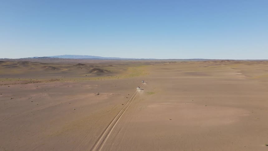 Aerial panorama of two cars driving in the desert