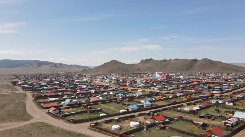 A region with many houses and fences close to a mountain