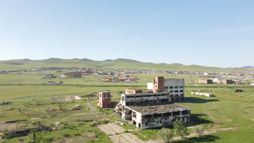 Aerial view of a building set slightly outside a small group of other buildings in a rural area