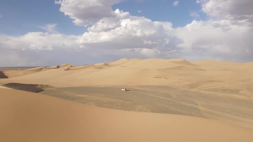 Panorama of a car parked in the middle of the desert