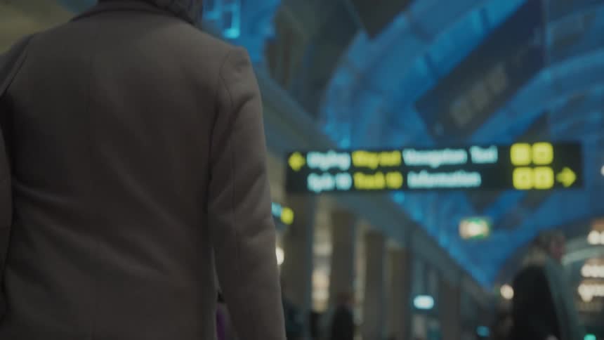 A male walking with a backpack in a crowded airport