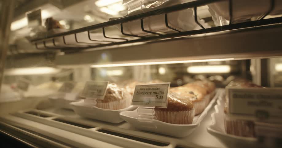 Several muffins on a shelf with signs with letters and numbers
