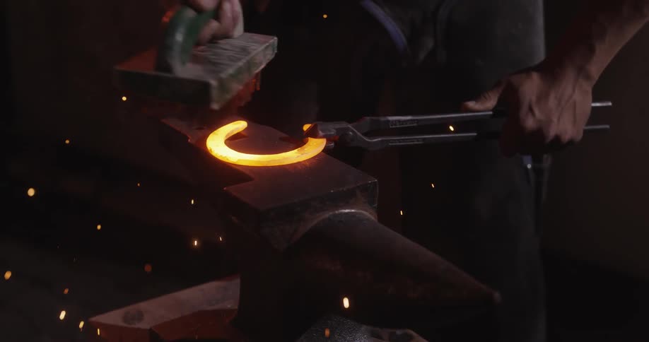 A person brush off a red hot steel with wire brush