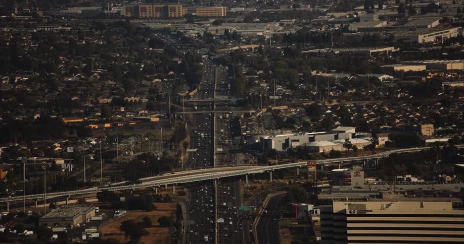Oakland, CA, with a highway and many buildings and cars near trees