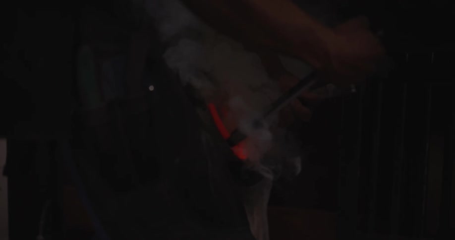 A farrier shoeing a horse inside a stable