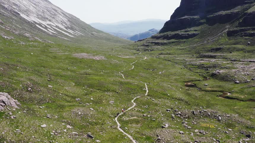 Mountaineers hiking on a path through the mountains
