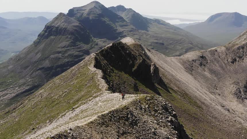 People walking on top of a rocky mountain