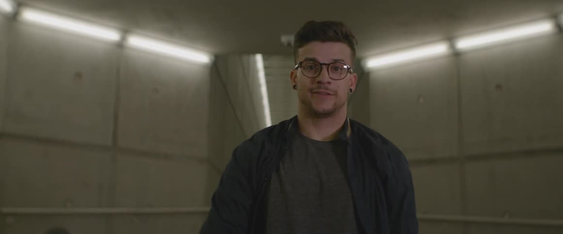 A man runs down a long hall and begins dancing