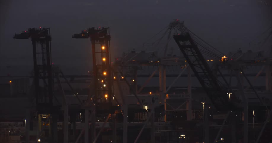 Night time helicopter aerial of cranes at the Port of Oakland
