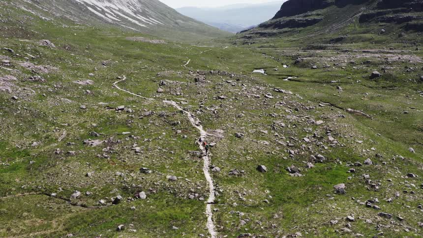 Aerial panorama of people hiking amidst the mountains