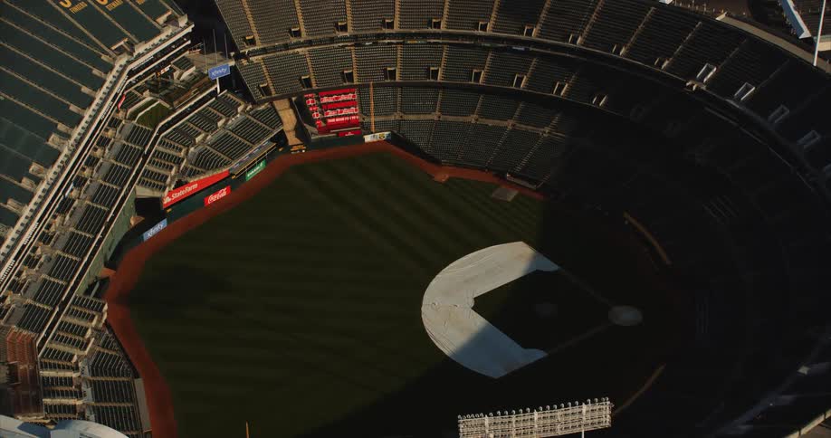 Helicopter aerial over Oakland CA's baseball stadium in partial sunlight