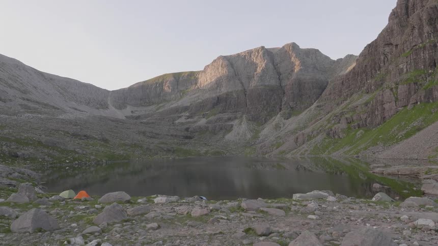A small lake is surrounded my an incredibly rocky mountain range