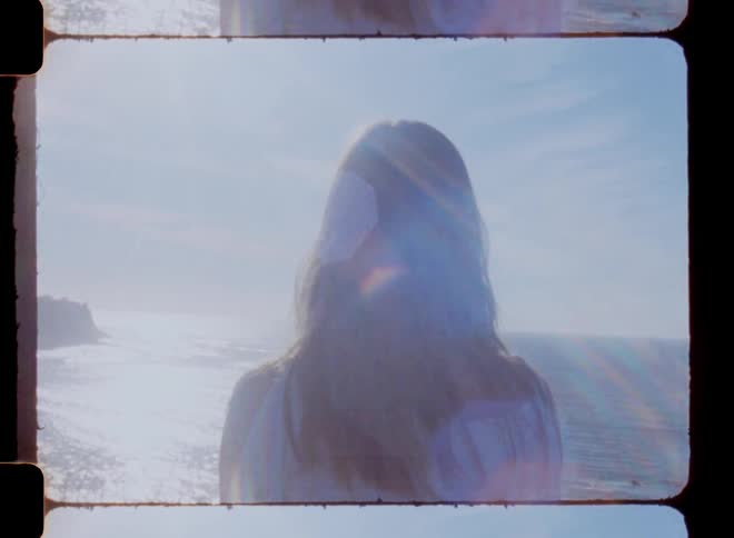 Woman with her hair blowing in the wind looking at the ocean