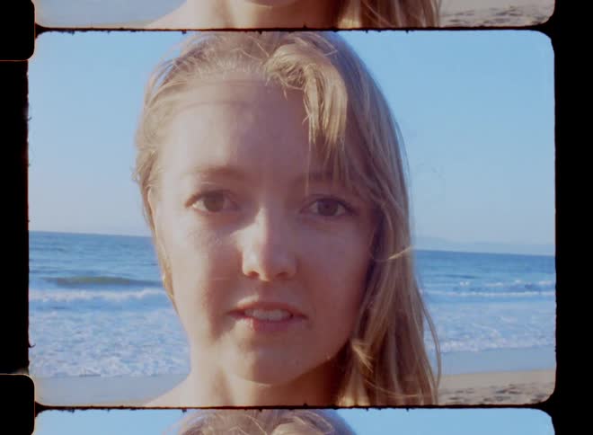 Woman with her hair blowing in the wind next to the beach