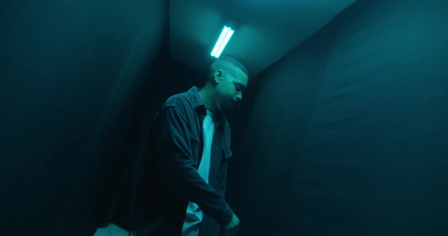Man in a dimly lit corridor enjoying and dancing