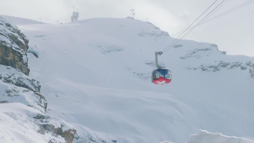 Cable car descending from a snow covered mountain
