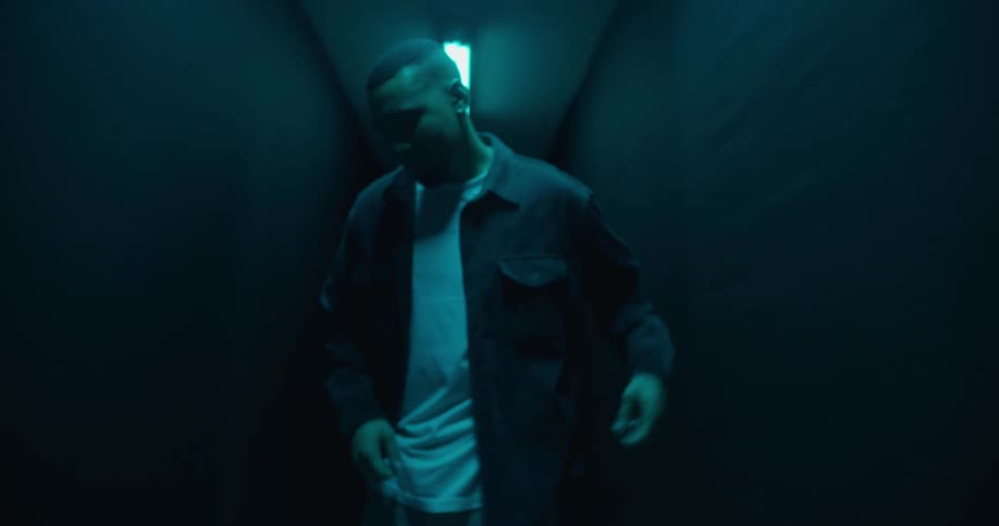 A black male dancing in a dimly lit hallway