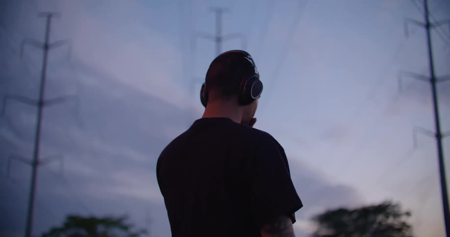 Man listens to music looking at the sky