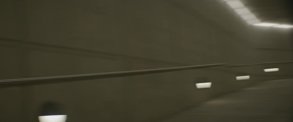 Man dances in a lighted tunnel at night