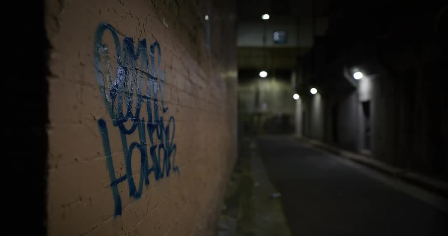 View of a city street with graffiti on the wall at night