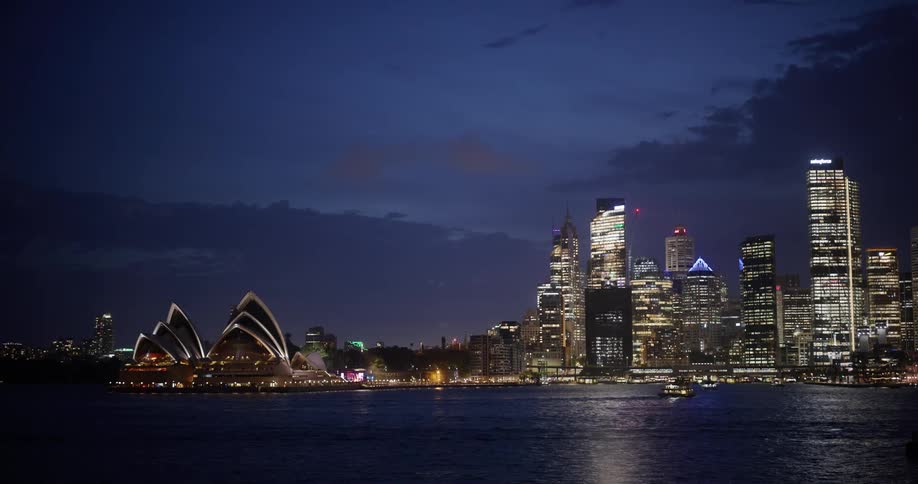 The tall buildings are bright lit at night