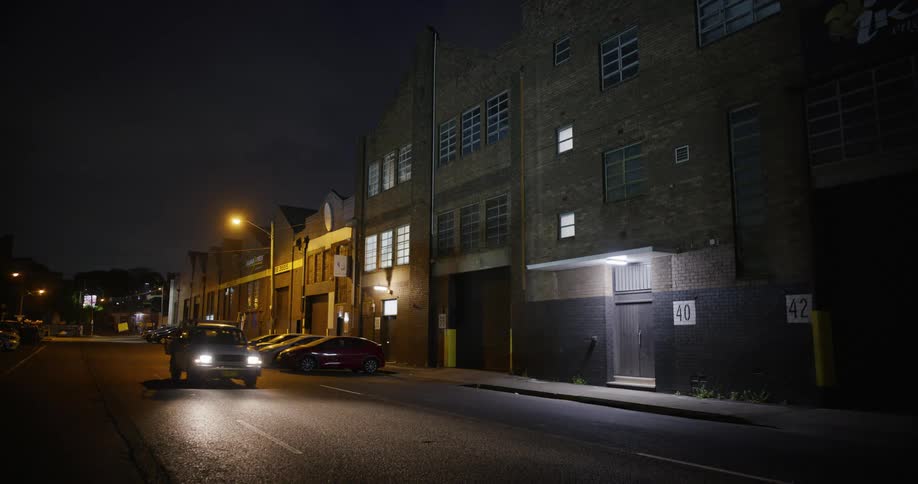A car drives down the road at night
