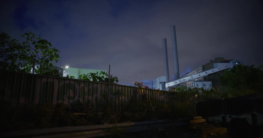 A factory building surrounded by a protective fence