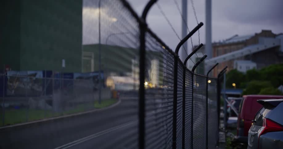 Closeup of an iron fence with wire on a city street