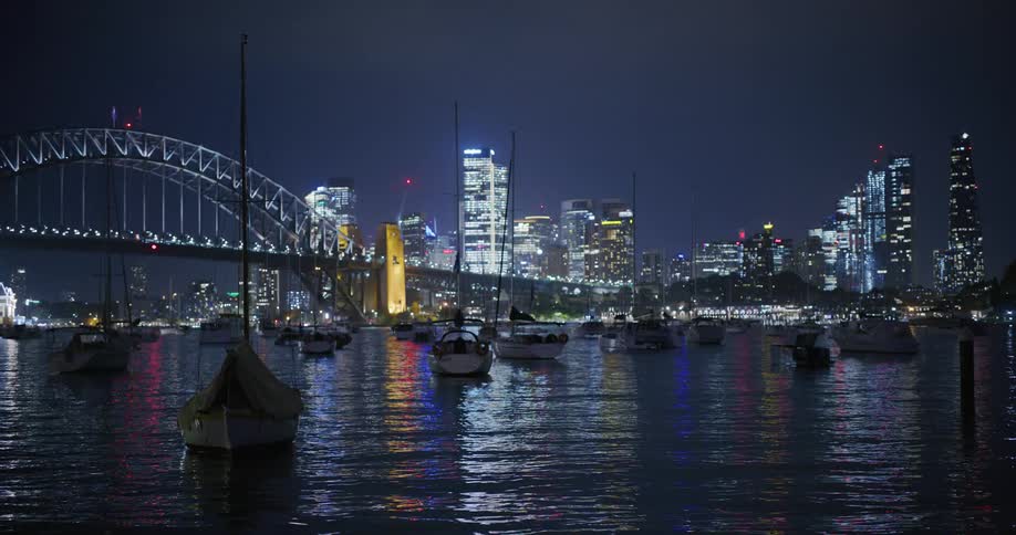 Boats anchored in the big citys marina while thunder flashes in the sky